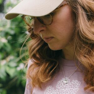 Image of a woman in a lilac t-shirt wearing a Potager Online Gardening Hat