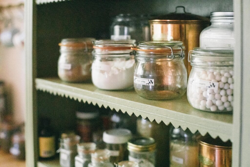 Photo of a shelf of jars holding food in an unfitted kitchen