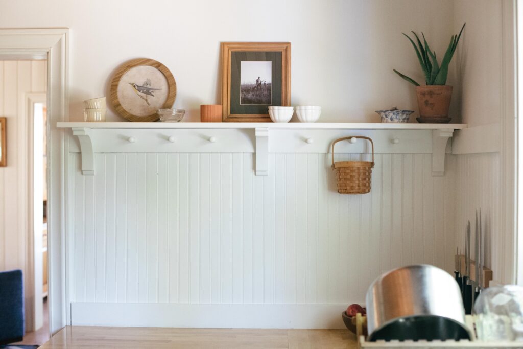 Image of open shelving white beadboard in an unfitted kitchen