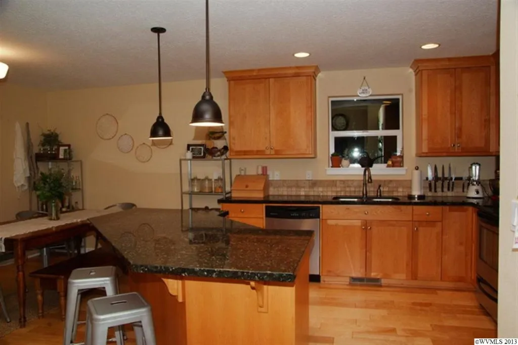 Image of a kitchen with wood cabinets and black counters