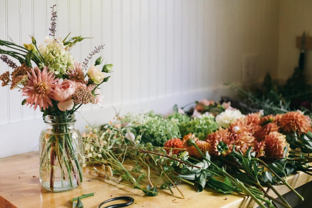 Image of a bouquet of garden flower arrangements being made in a white kitchen