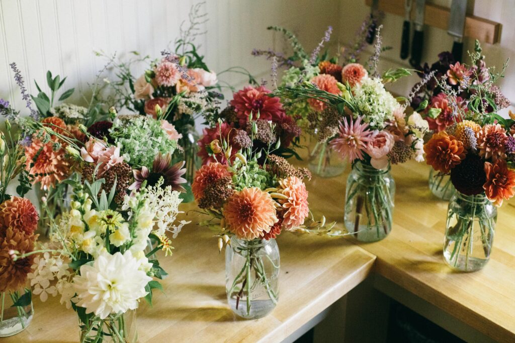 Image of a bunch of garden flower bouquets on a butcher block counter in a white kitchen