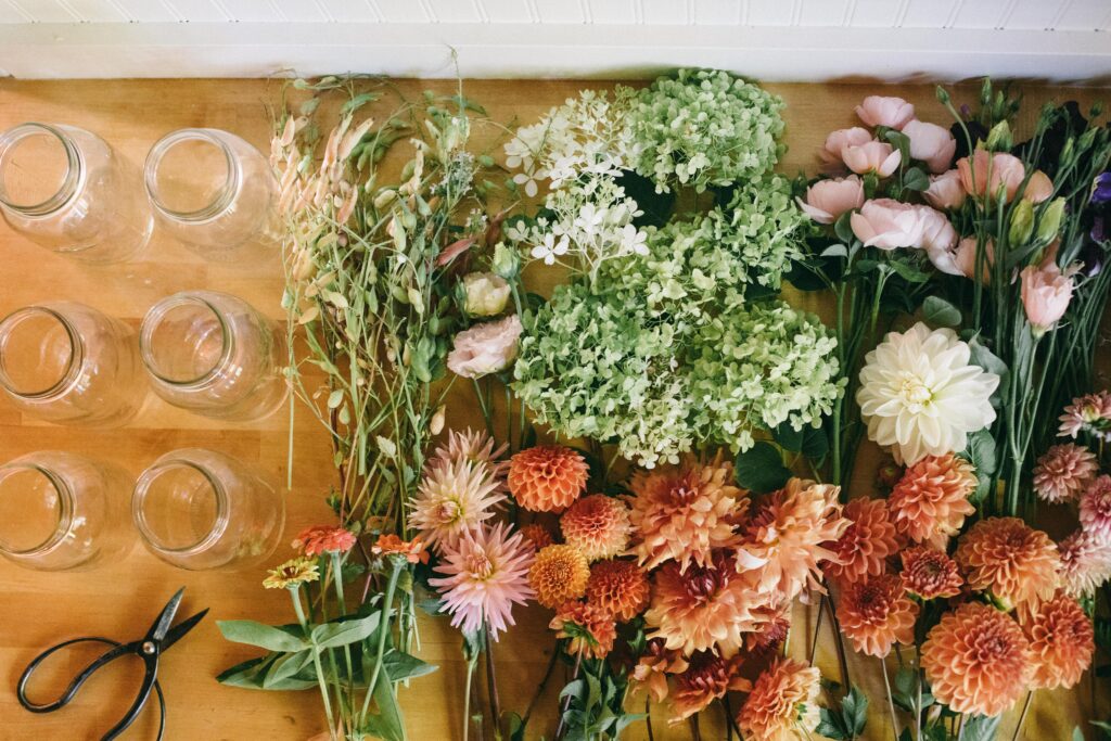 Image of garden flowers laid out on a butcher block counter with glass mason jars