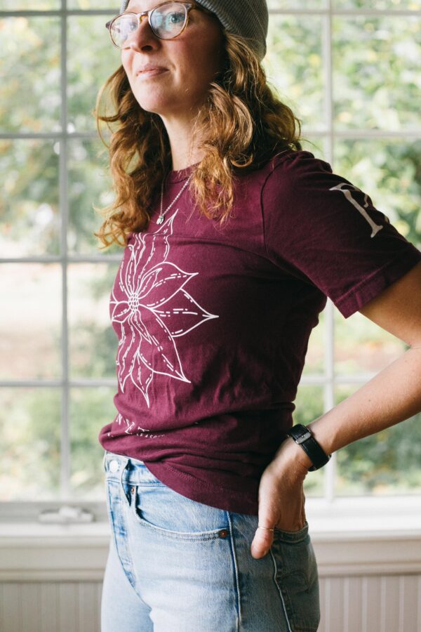 Image of a woman wearing a Potager Online Poinsettia Gardening Tee