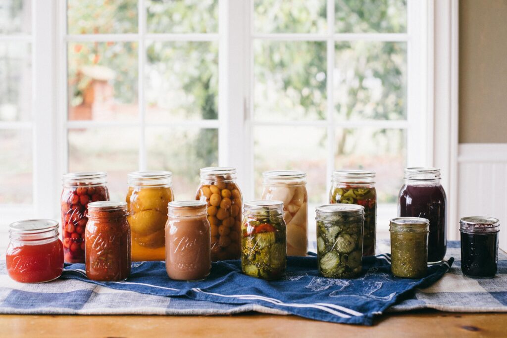 Image of a variety of canning preserves goodies laid out on a farm table